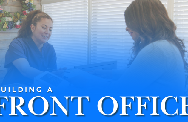 A front office staff member at a clinic assisting a patient with a welcoming smile.