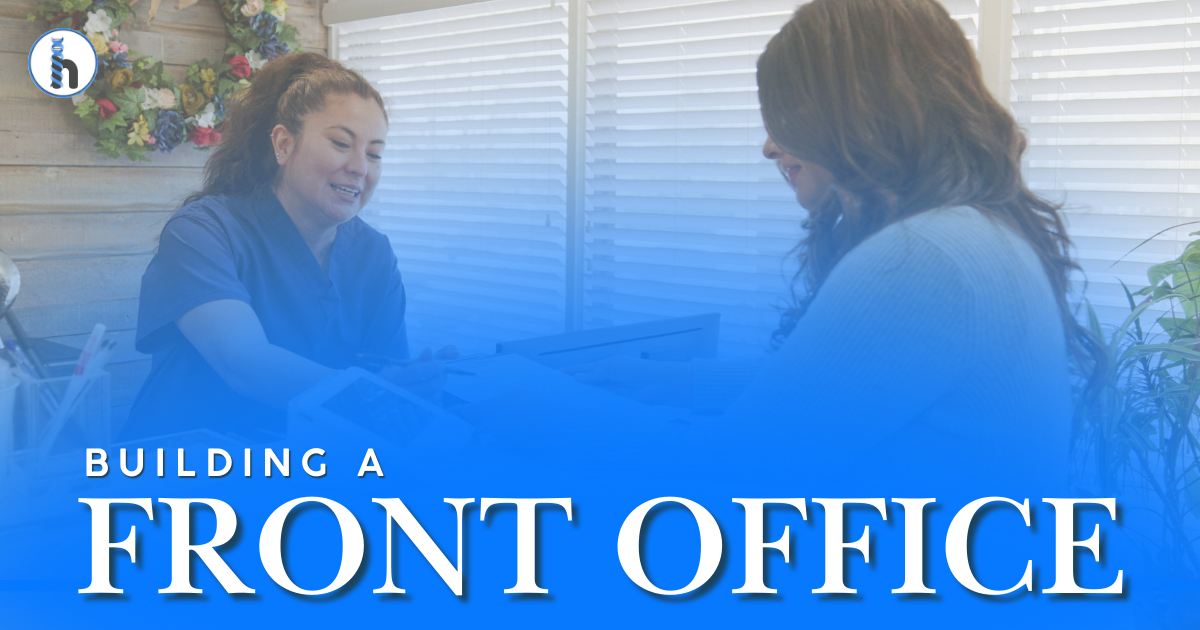 A front office staff member at a clinic assisting a patient with a welcoming smile.