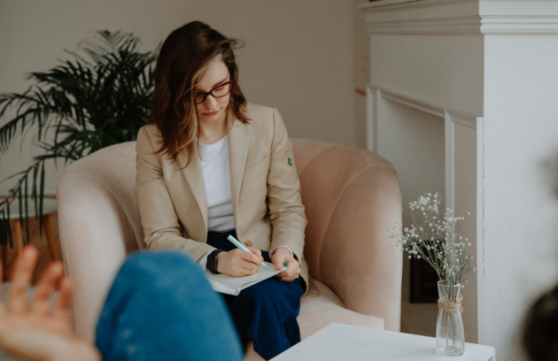 A focused therapist writing detailed notes while analyzing a complex case study, symbolizing effective complex case management.