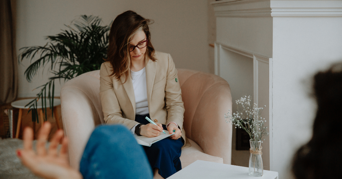 A focused therapist writing detailed notes while analyzing a complex case study, symbolizing effective complex case management.