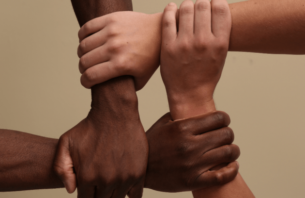 Four interlocked hands symbolizing unity, strength, and support in prosthetic rehabilitation for war veterans. Representing ProKinetics Physical Therapy’s dedication to advanced rehabilitation, holistic healing, and the seamless integration of HelloNote EMR for efficient patient care and compliance.