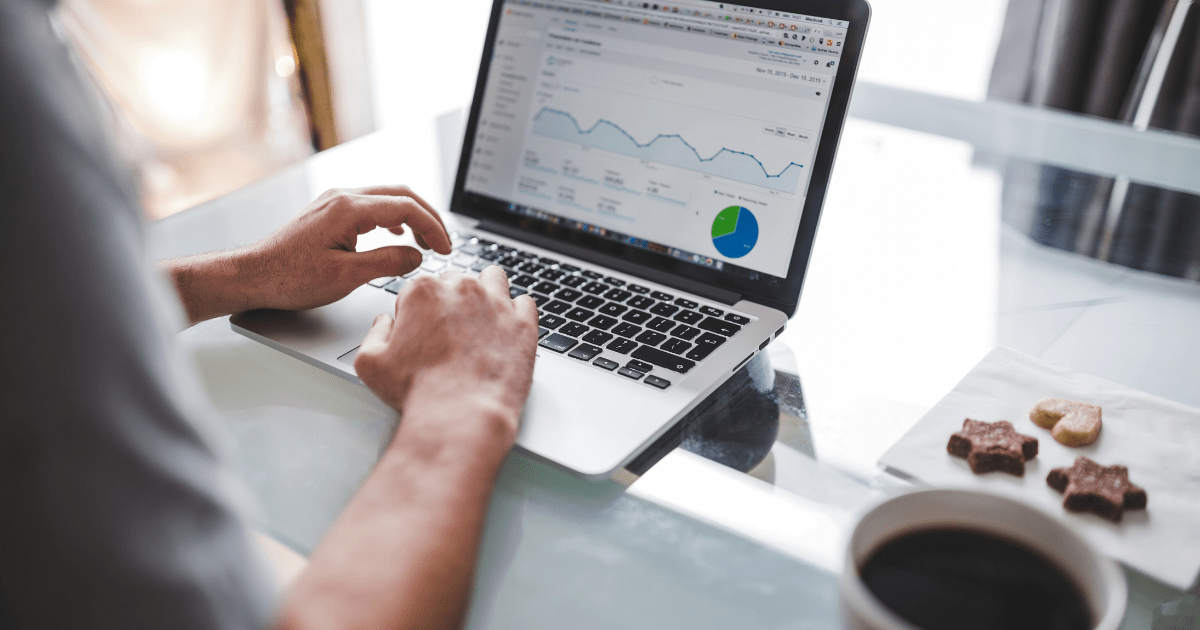 Hands typing on a laptop displaying marketing analytics graphs, representing the data-driven approach to **physical therapy marketing strategies** for **attracting physical therapy patients** and **growing your physical therapy clinic**.